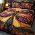 Glowing Wings quilted 3-piece bedding set on a made bed with two matching pillow shams