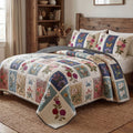 Petal Garden Retreat quilted 3-piece bedding set on a made bed with two matching pillow shams